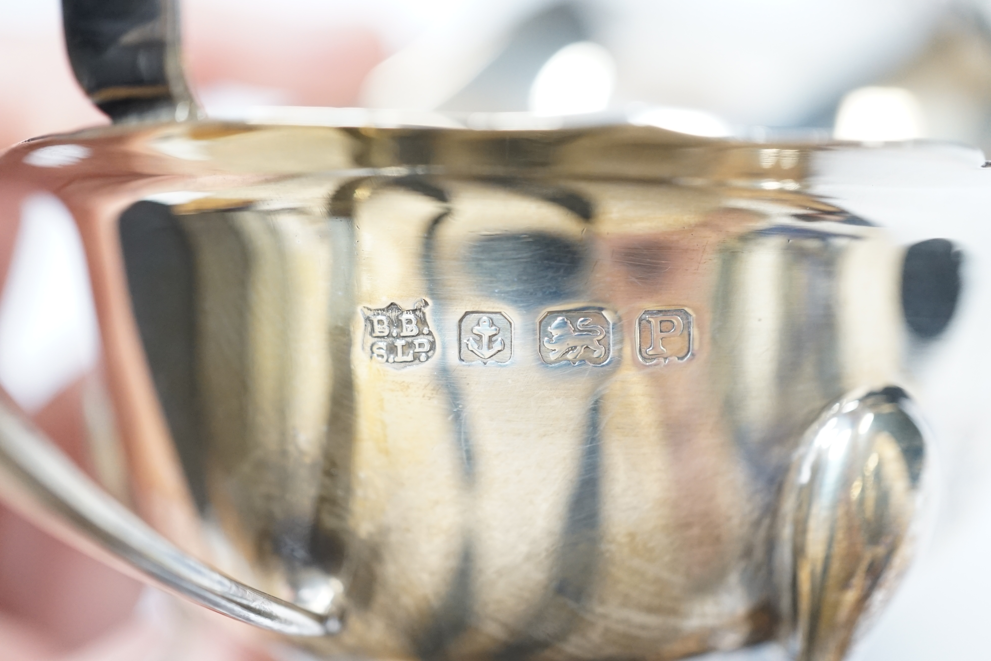 A George V silver christening mug, with card cut decoration, Adie Bros. Birmingham, 1903, height 81mm, a silver sauceboat, a dish, a pair of modern silver goblets and a 1970's silver mounted glass 'swan' bonbon dish.